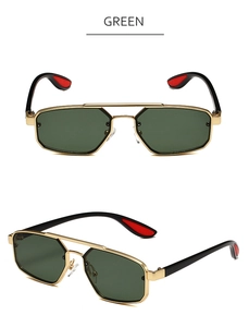 Détail de lunettes de soleil hexagonales dorées à double pont avec verres vert foncé et embouts rouges