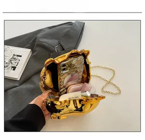 Capacity display of golden pig acrylic evening bag showing phone and cosmetics space