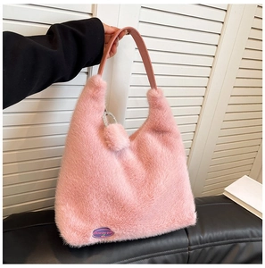 Detail of pink faux fur handbag featuring leather handle and rhinestones ring charm