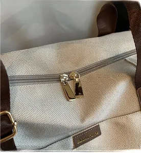 Close-up of high-density fabric texture and golden dual zippers on a large travel bag