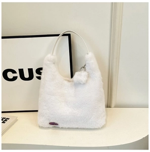 Detail shot of soft white plush handbag featuring a signature purple brand label