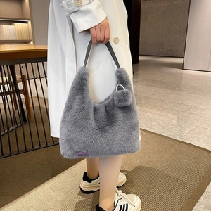 Detail of soft gray faux fur handbag with leather handle and fashion tag accent