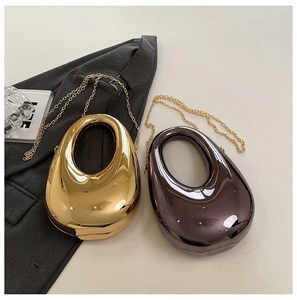 Detail of tear-drop hard shell evening bags in gold and grey with metallic chain
