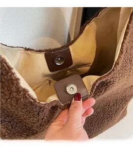 Dettaglio della borsa tote in peluche caramello con chiusura magnetica in pelle e tasca