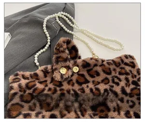 Close-up of leopard print plush bag with gold magnetic buckle and pearl strap