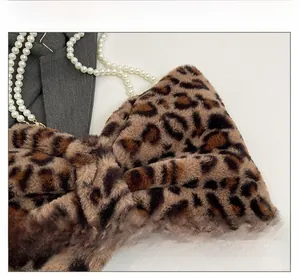 Detail shot of leopard print faux fur bow bag with dual imitation pearl chain straps