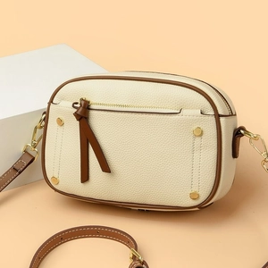 Elegante borsa beige in pelle con accenti marroni e dettagli di borchie dorate
