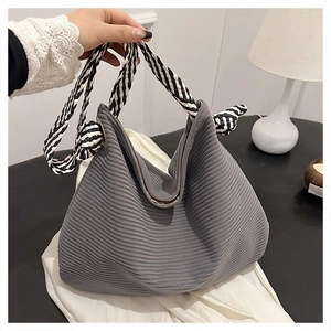 Dettaglio borsa tote in velluto a coste grigio con manici a corda intrecciata
