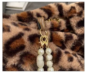 Detail of leopard print plush bag with pearl chain strap and golden hardware
