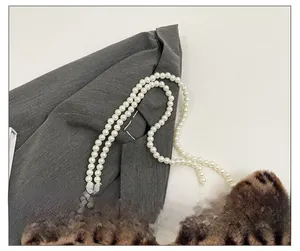Close-up of leopard print plush bag featuring double-strand white pearl chain strap