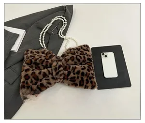Detail of leopard print plush bow bag with dual elegant pearl handles and soft faux fur