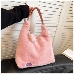 Chic pink faux fur underarm bag with purple logo patch and stylish fluffy pompom detail