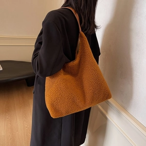 Borsa tote in peluche marrone con tracolla in pelle indossata da una modella