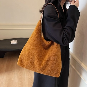 Borsa tote in ecopelliccia color caramello con tracolla in pelle indossata da modella