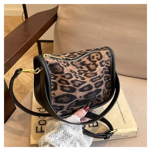 Close-up of leopard print PU shoulder bag featuring gold hardware and black leather trim
