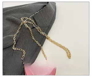 Detailed close-up of a premium gold metal chain strap on a pink heart acrylic handbag