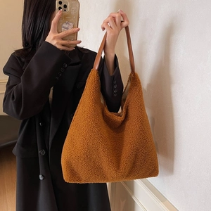 Dettaglio della borsa hobo in peluche caramello con manico in pelle e anello di metallo