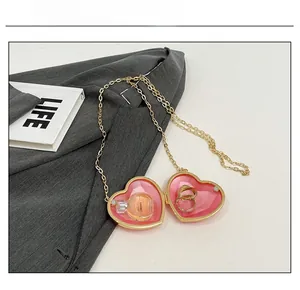 Detail of a heart-shaped gold locket pendant showing interior storage for rings or perfume