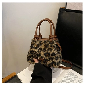 Détail du sac bandoulière en fausse fourrure léopard avec anses en cuir à nœuds