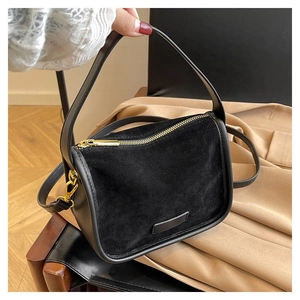 Detail of black matte PU leather handbag showing smooth trims and golden metal hardware