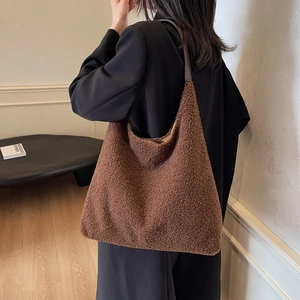 Vista dettagliata della grande borsa tote in peluche marrone con tracolla sottile