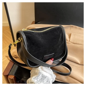 Detail of black matte suede shoulder bag with gold hardware and smooth leather trim