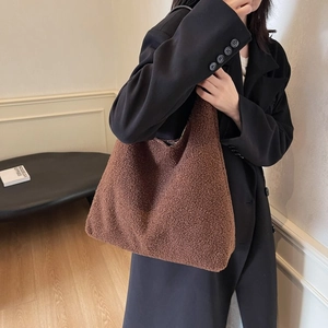 Dettaglio della borsa tote in peluche marrone con modella in un interno minimalista
