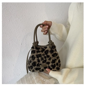 Détail du sac en fausse fourrure léopard avec anse nouée et logo doré