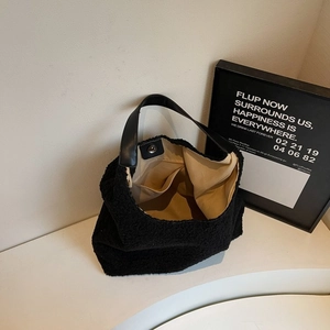 Dettaglio della borsa tote in sherpa nera con chiusura magnetica e fodera in tessuto beige