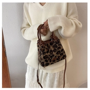 Détail d'un sac à main léopard en fausse fourrure avec poignées en cuir et nœuds