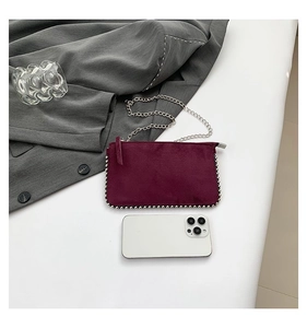 Deep magenta frosted suede mini bag with silver bead trim and chain strap shown with phone