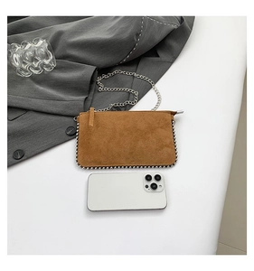 Detail of brown suede envelope bag with silver metallic bead trim and chain strap
