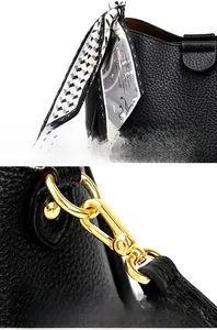 Detail of lychee pattern leather handbag with printed silk ribbon and gold-tone hardware