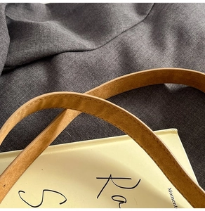 Gros plan de la bandoulière en cuir marron avec coutures fines et texture raffinée