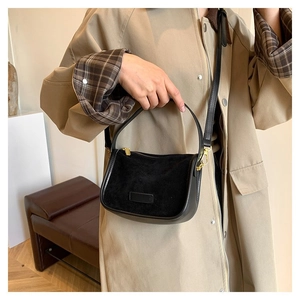 Detail of black half-moon crossbody bag in matte suede and smooth synthetic leather