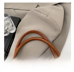 Macro detail of brown leather bag strap with exquisite stitching on a chic background