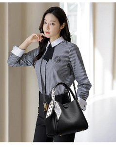 Close-up of black lychee leather handbag with a geometric silk scarf wrapped on the handle
