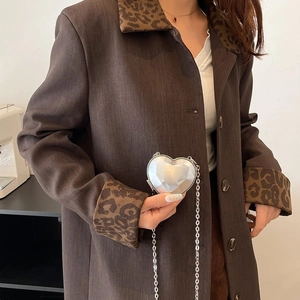 Silver heart-shaped mini chain bag with metallic faceted texture worn by a model