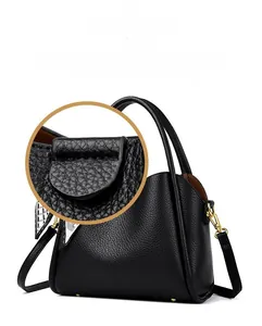 Detail shot of black litchi texture leather handbag with precise stitching and gold hardware