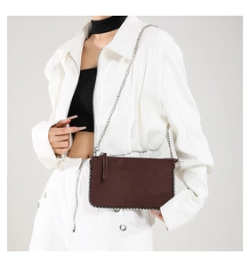 Detail of dark brown suede crossbody bag with silver beaded trim and chain strap