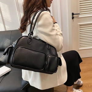 Model wearing a black multi-pocket tote bag in premium faux leather for a modern work look