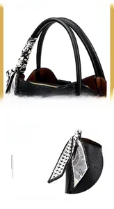 Detail of black litchi grain leather handbag with silk ribbon and interior zipper pocket