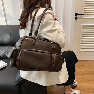 Detail of a dark brown vintage faux leather shoulder bag with multiple functional pockets