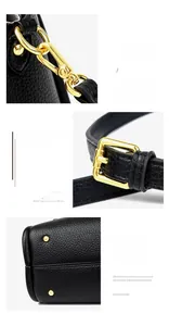 Detail of black lychee leather bag with gold hooks and bottom metal rivets