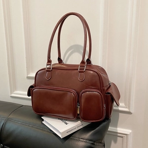Detail of vintage brown shoulder bag with multiple zippered pockets and shiny PU leather finish