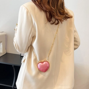 Detail of pink resin heart-shaped mini bag with faceted surface and gold chain strap