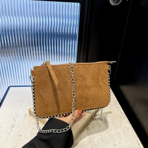 Detail view of brown suede envelope bag with silver metallic bead trim and chain strap