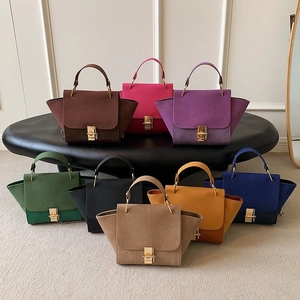 Close-up of trapeze shoulder bags with metal locks and contrasting textures in various colors