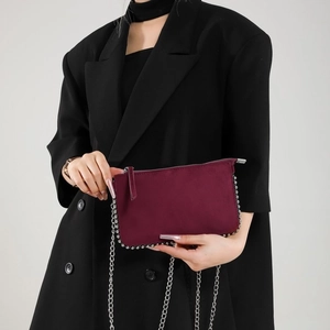 Detail of burgundy suede mini square bag with silver metal bead trim and chain strap