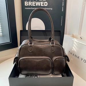 Detailed view of dark brown faux leather bag with dual zipper pockets and silver hardware
